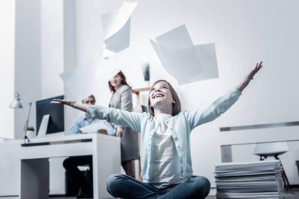 istock Excited girl having fun and throwing papers in office 913308172