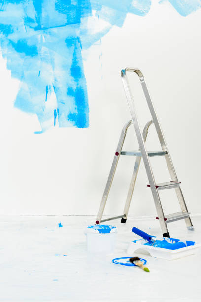 istock ladder and paint roller brush in blue paint 913312354
