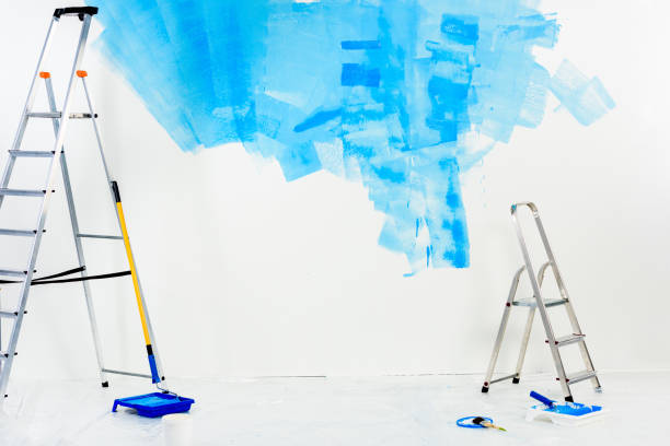 istock ladders and paint roller brushes in blue paint 913312368