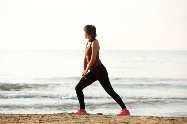 istock Full length beautiful jogger stretching muscles after workout on beach 913320222