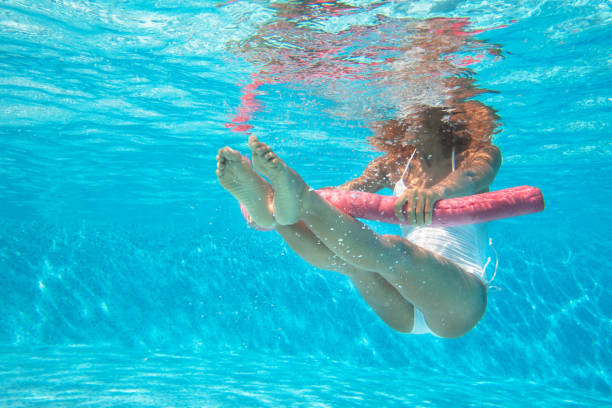 frau tut wassergymnastik im pool - aerobics stock-fotos und bilder