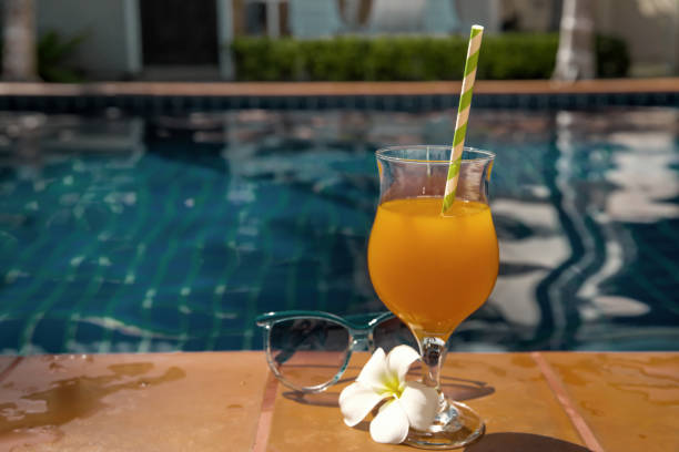 istock Orange juice with sunglasses on swimming pool 913326330