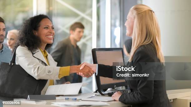 Female Rental Clerk Giving Documents To Female Customer Renting Car Stock Photo - Download Image Now