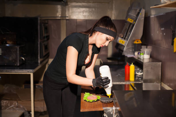 istock woman Cook prepares a burger in the kitchen 913334604