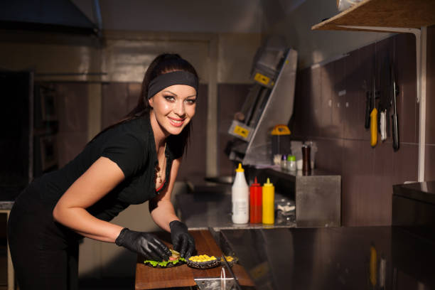 istock woman Cook prepares a burger in the kitchen 913334920