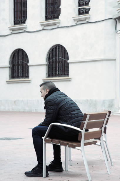istock sad man sitting in a bench in the street 913339202