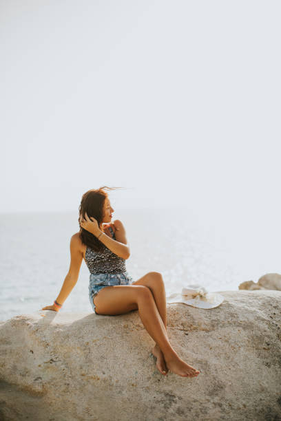 istock Pretty young woman on the beach 913342156