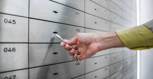 istock Bank clerk opening safe deposit box 913342708