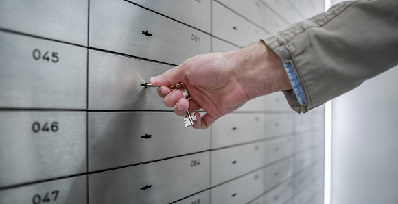 Businessman unlocking safe deposit box.