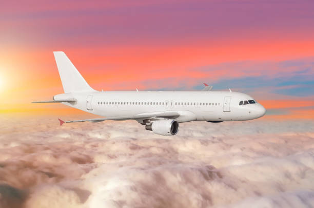 istock Flying airplane above the clouds horizon sky with bright sunset colors. 913343044
