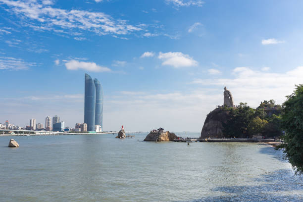China Xiamen landmark landscape：Chic shape of the skyscraper and the Chinese national hero Zheng Chenggong statue opposite the sea, is the landmark of Xiamen City.