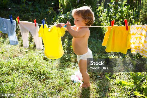 Fun Happy Baby Girl To Wash Clothes And Laughs In The Meadow On A Sunny Summer Day Stock Photo - Download Image Now