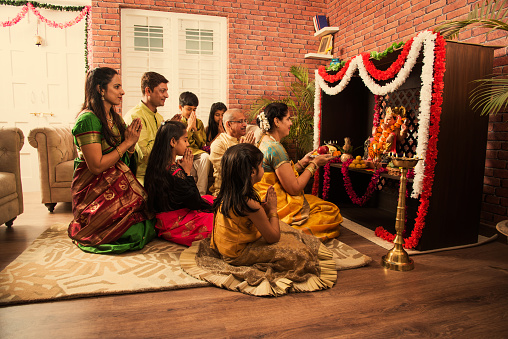Familia India realizando Ganesh puja o Ganpati Puja en Ganesh Utsav, o celebración de ganesh ídolo sobre fondo blanco photo