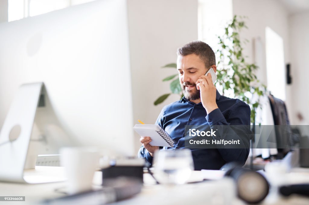 Kaufmann im Rollstuhl am Schreibtisch in seinem Büro. - Lizenzfrei Am Telefon Stock-Foto