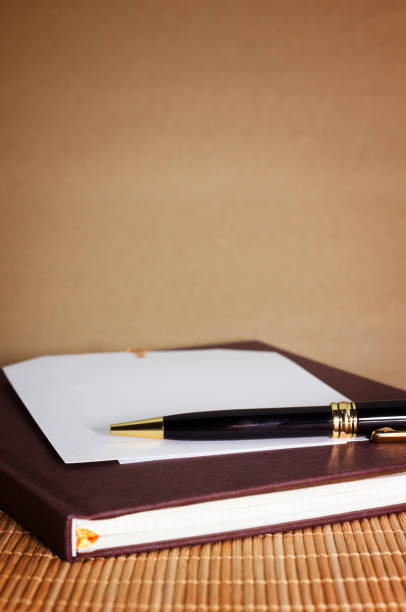 istock note paper and black pen on brown background 913347228