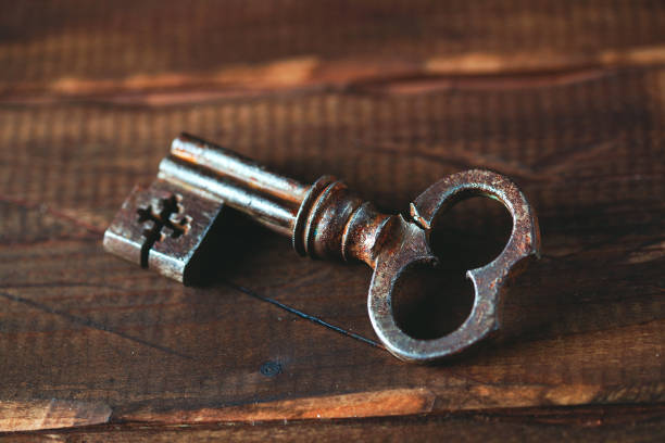 istock old metal key on a wooden background, rustic style 913347718