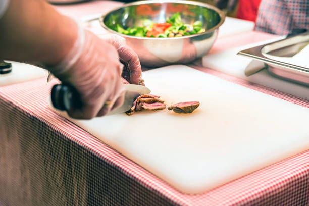 istock Hands slice piece of steak on white board 913351536