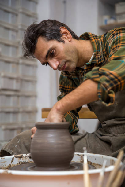 istock Artist makes clay pottery on a spin wheel in workshop 913358188