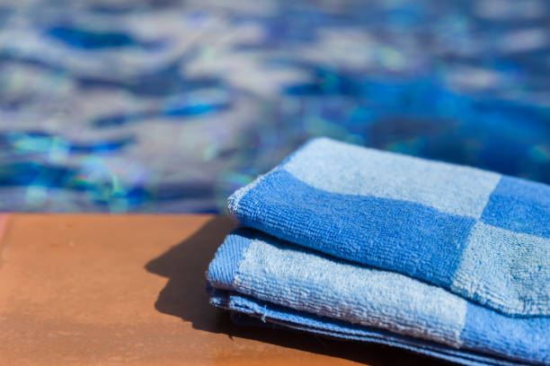 istock Fluffy blue towel on border of a swimming pool 913363234