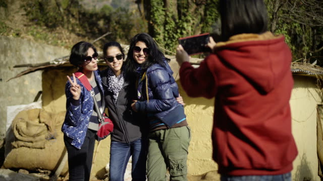 Urban young women taking pictures, having fun in a village.