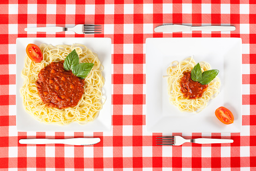 Contrasting large and tiny food portions of Spaghetti