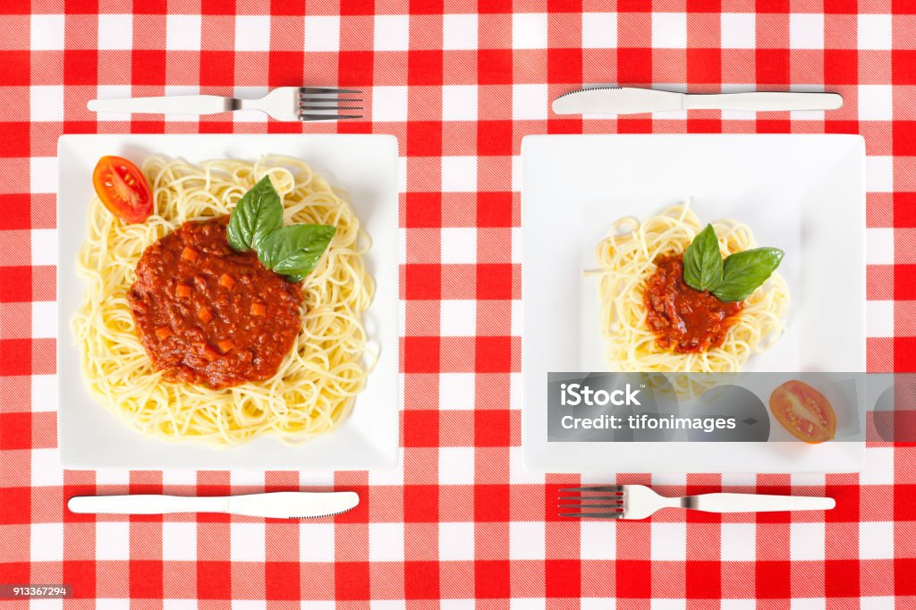 large and tiny food portions Contrasting large and tiny food portions of Spaghetti Serving Size Stock Photo