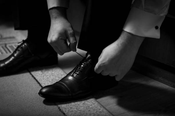 istock Bridegirl binds his shoes in black and white. 913369912