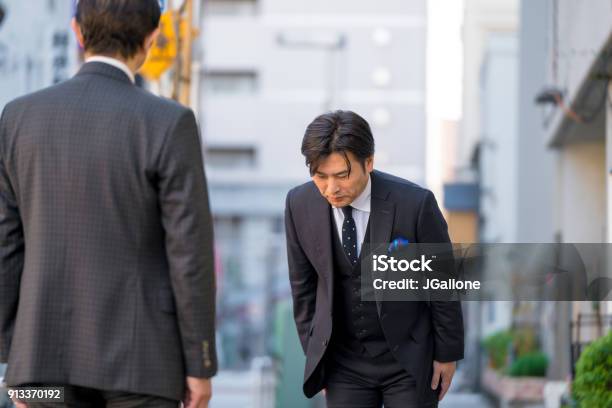 Mature Japanese Businessman Bowing To Show Respect Stock Photo - Download Image Now - Bowing, Japan, Greeting