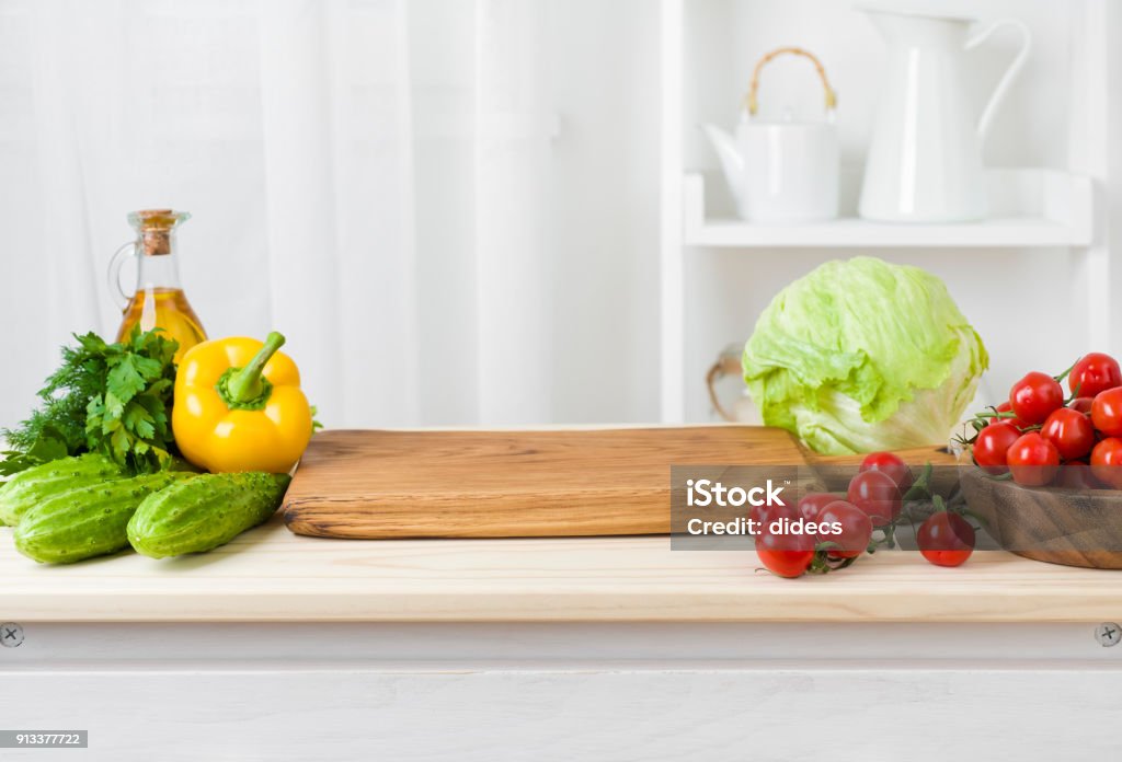 Table de cuisine avec planche à découper pour la préparation de salades et de légumes - Photo de Table libre de droits