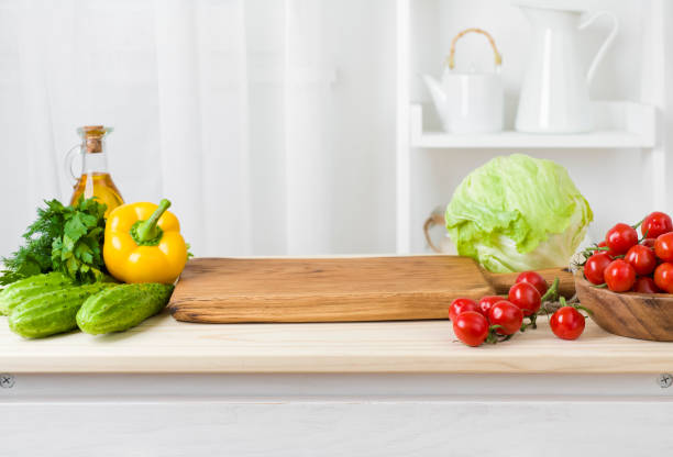 kitchen table with vegetables and cutting board for preparing salad - vegetables table imagens e fotografias de stock