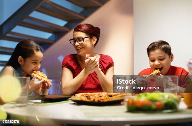 Home Dinner With Happy Family Eating Homemade Pizza Stock Photo - Download Image Now