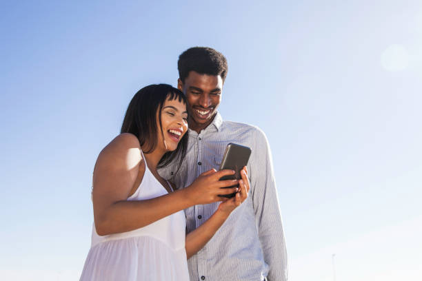 istock Young man and woman looking at something on a mobile phone together. 913382332