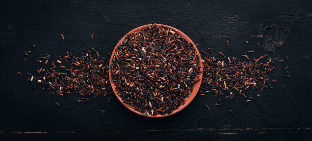 istock Black dry rice. On a wooden background. Top view. Copy space. 913382850