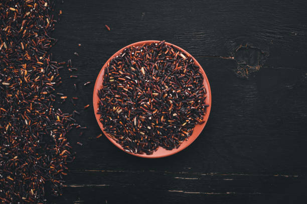 istock Black dry rice. On a wooden background. Top view. Copy space. 913386508