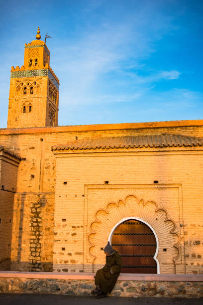 marroquina berbere sentado pela mesquita de koutoubia, marrocos. - djemma el fna square - fotografias e filmes do acervo