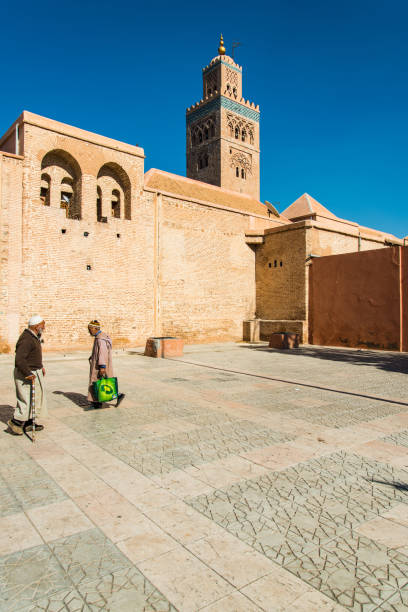 mem muçulmano caminhar pela mesquita de koutoubia, em marrocos. - djemma el fna square - fotografias e filmes do acervo