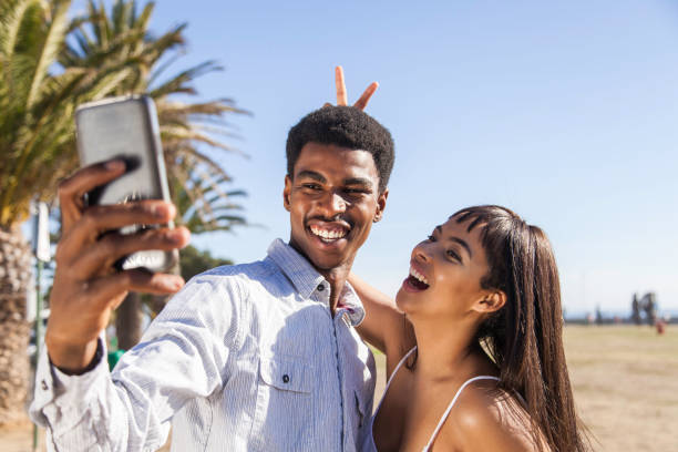 istock Good looking young man and woman taking selfies together. 913407246