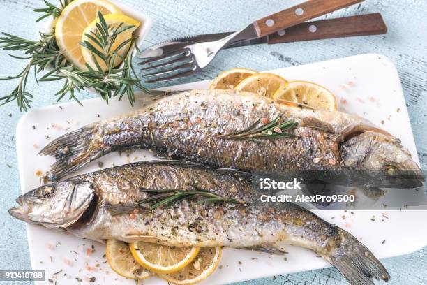 Baked Sea Bass With Lemon And Rosemary Stock Photo - Download Image Now - Fish, Sea Bass, Whole