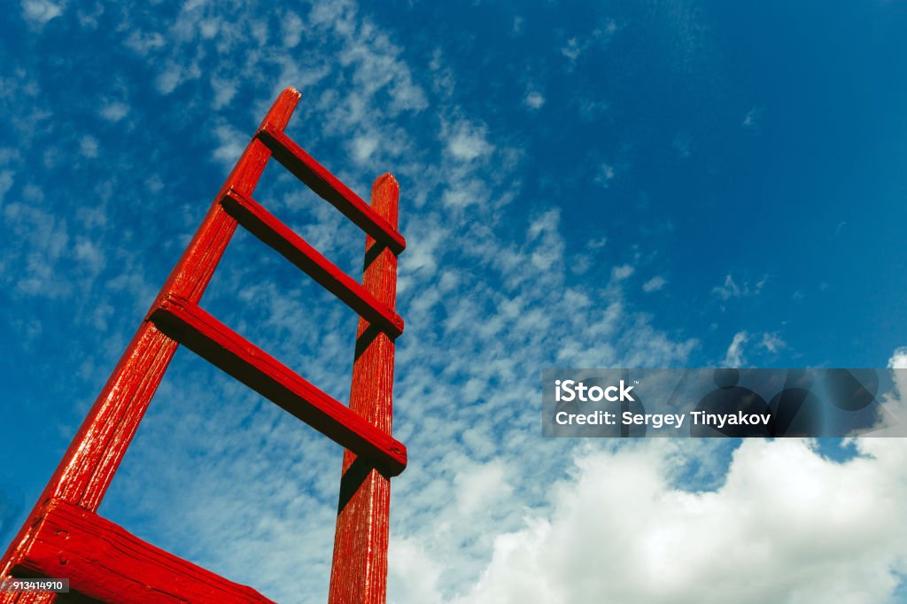 Escalera de madera rojo contra el azul del cielo. Concepto de crecimiento de desarrollo motivación negocio carrera cielo - Foto de stock de Rojo libre de derechos