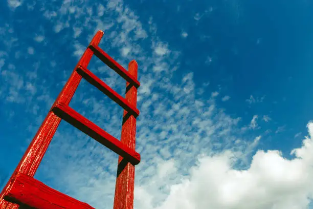 Photo of Red wooden staircase against the blue sky. Development Motivation Busines Career Heaven Growth Concept