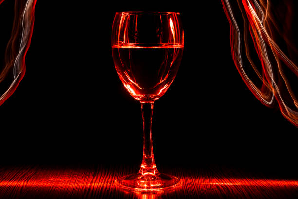 istock A transparent glass of wine with a liquid. Red blurred bands. Light effect. 913415344