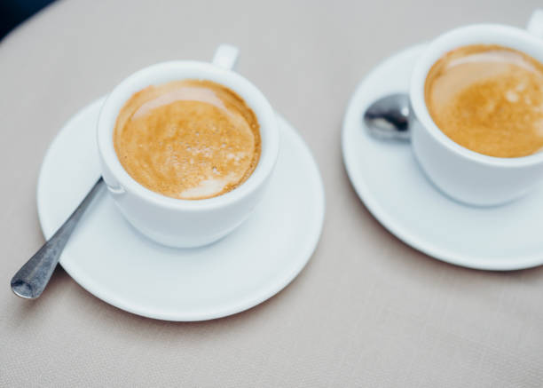 istock Two cups of coffee at the light table. 913415962