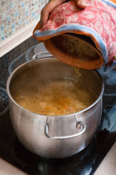 istock the cook puts sauerkraut from pot into saucepan 913422136
