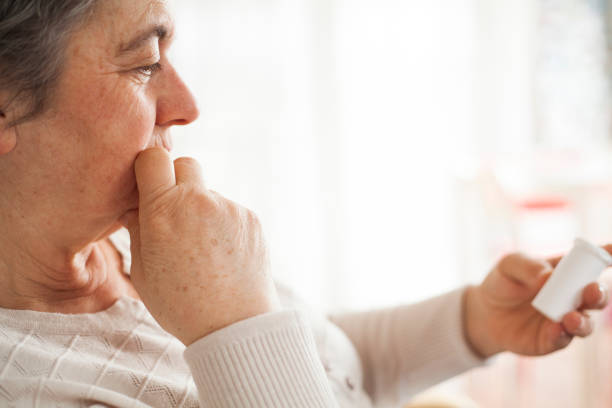 istock senior woman taking pills 913423750