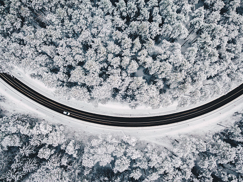 Drone aerial view of road in the snowy forest. Kaunas county, Lithuania