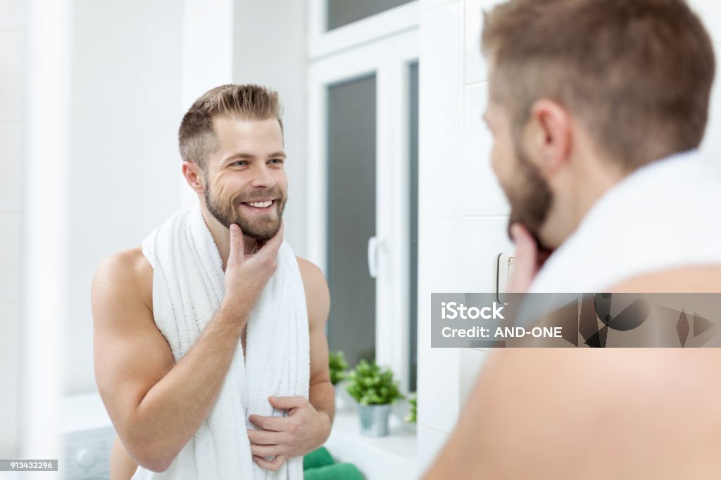 Higiene de la mañana, hombre en el baño mirando en el espejo - Foto de stock de Hombres libre de derechos