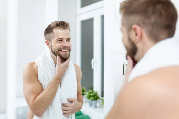 morning hygiene, man in the bathroom looking in mirror - soap body imagens e fotografias de stock