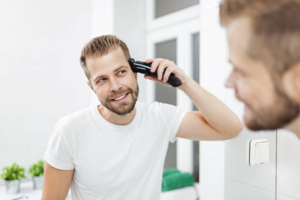 istock Handsome man cutting his own hair with a clipper 913434846