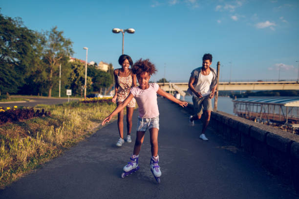 istock Parents assisting their daughter while roller skating at sunset 913435140