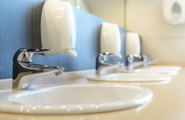 Silver faucet and white sink Silver faucet and white sink in a new public toilet room empty. Shallow DOF public restroom photos stock pictures, royalty-free photos & images
